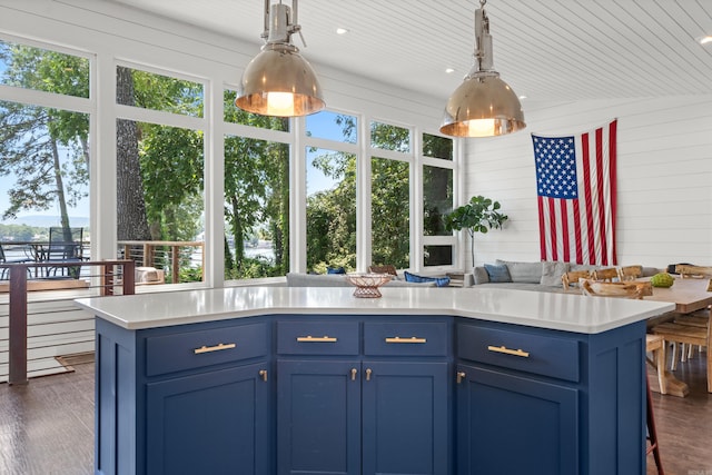 kitchen featuring hanging light fixtures, a kitchen breakfast bar, dark hardwood / wood-style floors, and blue cabinets