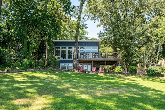 back of house with a wooden deck and a lawn