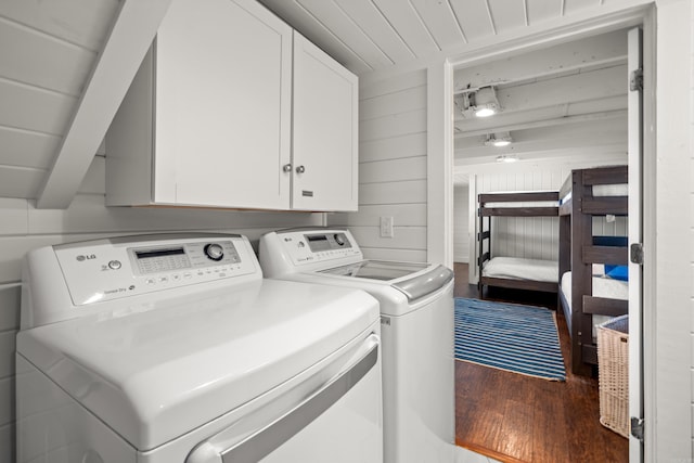 laundry room with cabinets, dark wood-type flooring, and washing machine and clothes dryer