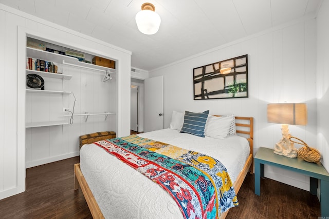 bedroom with ornamental molding, dark hardwood / wood-style floors, and a closet