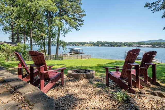 view of yard featuring a dock, a water view, and an outdoor fire pit