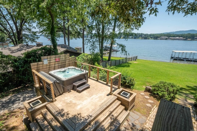 deck with a boat dock, a water view, a yard, and a hot tub