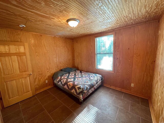 bedroom featuring wooden ceiling and wood walls