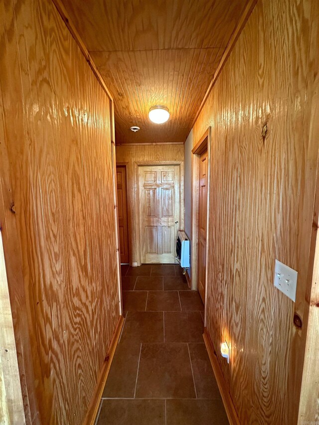 hall with heating unit, wooden ceiling, and wood walls