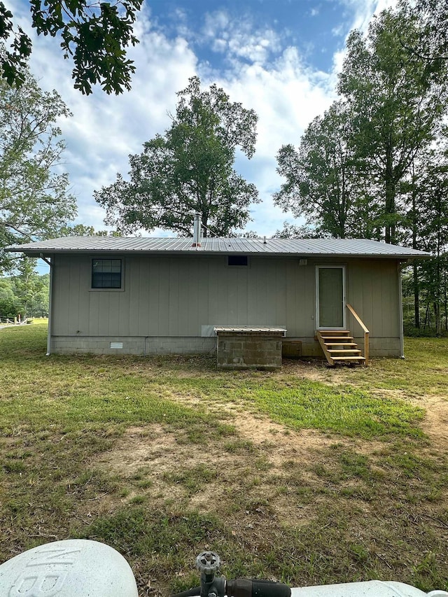 rear view of property featuring a yard