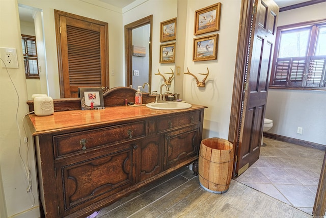 bathroom featuring crown molding, oversized vanity, and toilet