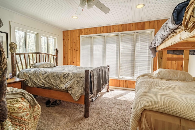 bedroom featuring carpet, ceiling fan, and wood walls