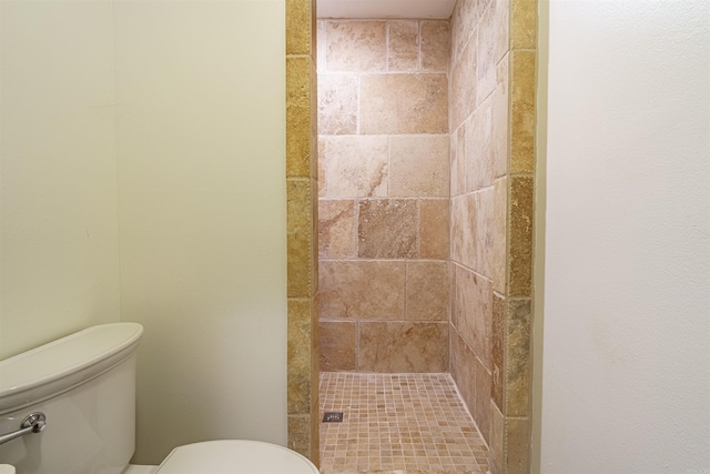 bathroom featuring a tile shower and toilet