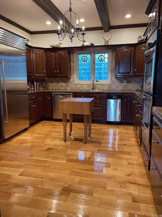 kitchen with decorative light fixtures, light hardwood / wood-style floors, tasteful backsplash, beamed ceiling, and appliances with stainless steel finishes