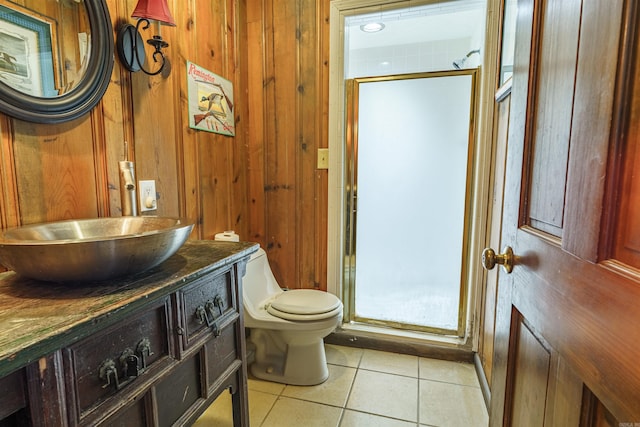 bathroom with wood walls, toilet, tile floors, walk in shower, and vanity