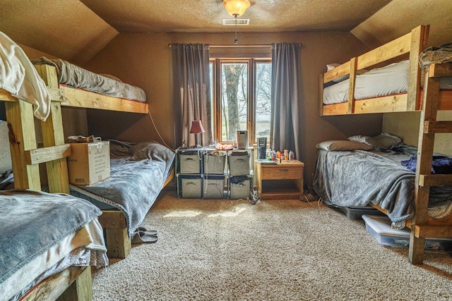 carpeted bedroom with vaulted ceiling and a textured ceiling