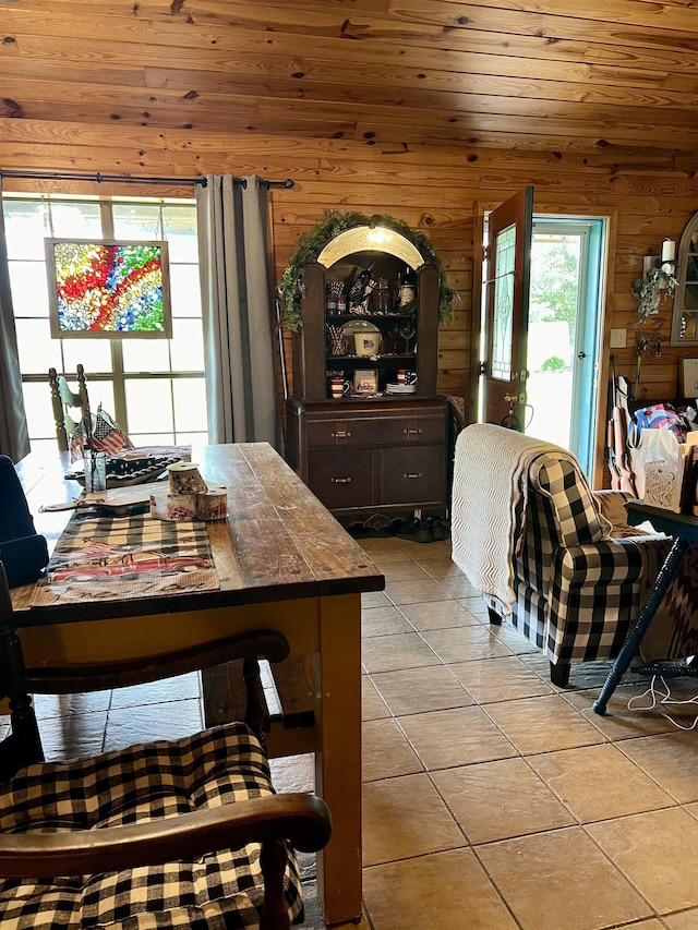 dining area featuring light tile patterned floors, wood ceiling, and wood walls