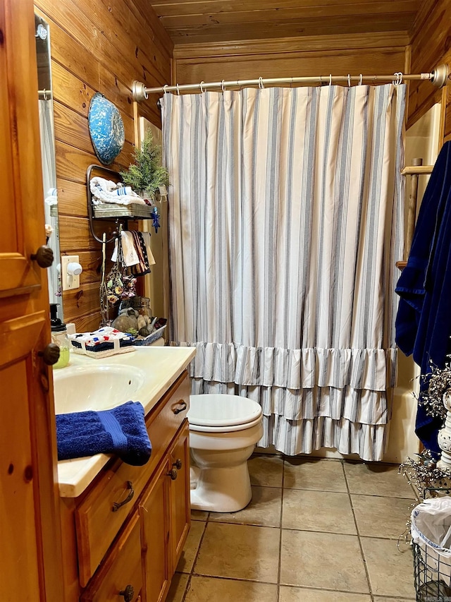 bathroom featuring vanity, toilet, tile patterned flooring, and wood walls