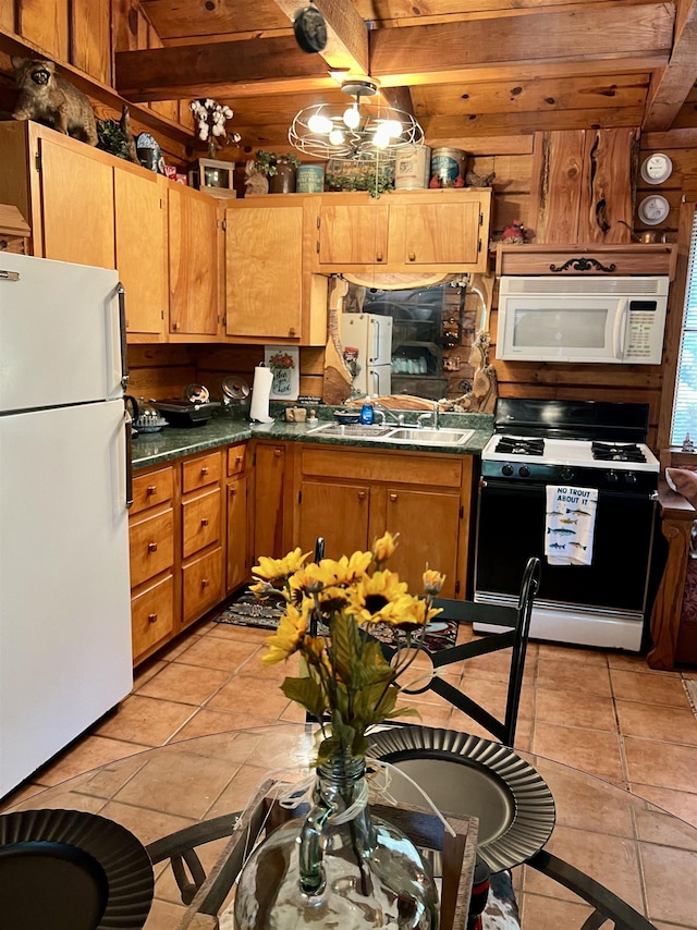 kitchen with beam ceiling, white appliances, and light tile patterned flooring