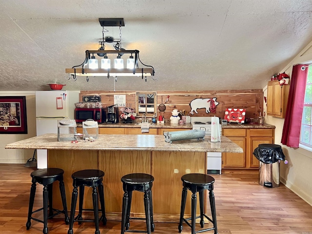 bar with light hardwood / wood-style floors and a textured ceiling