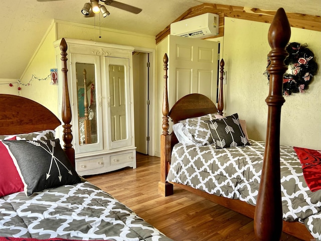 bedroom with lofted ceiling, crown molding, a wall mounted AC, hardwood / wood-style flooring, and ceiling fan