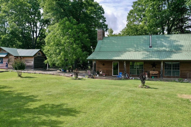 rear view of property featuring a patio area and a lawn