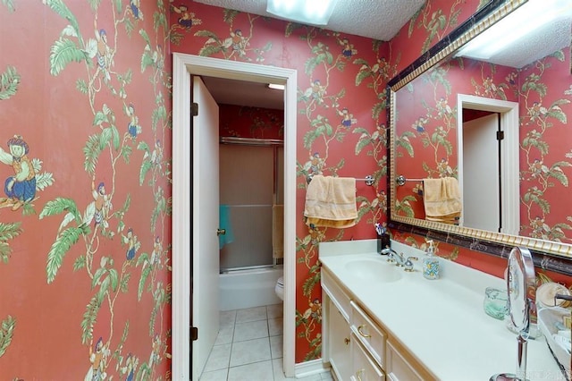 bathroom with tile patterned floors, a textured ceiling, vanity, and an enclosed shower
