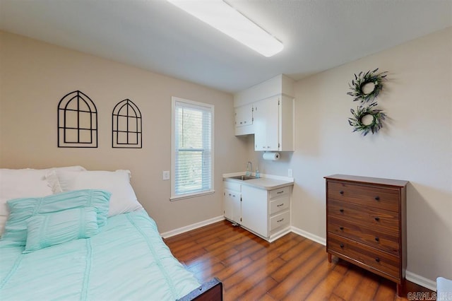bedroom featuring sink and dark wood-type flooring