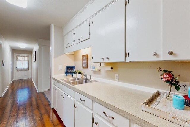 kitchen with dark hardwood / wood-style floors, white cabinetry, and sink