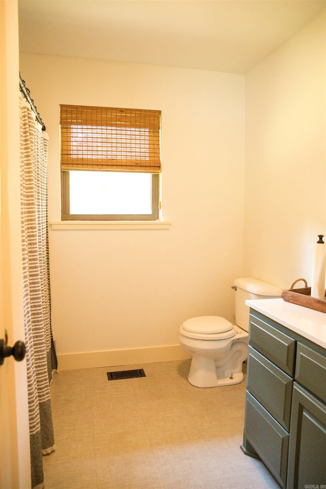 bathroom with tile floors, vanity, and toilet