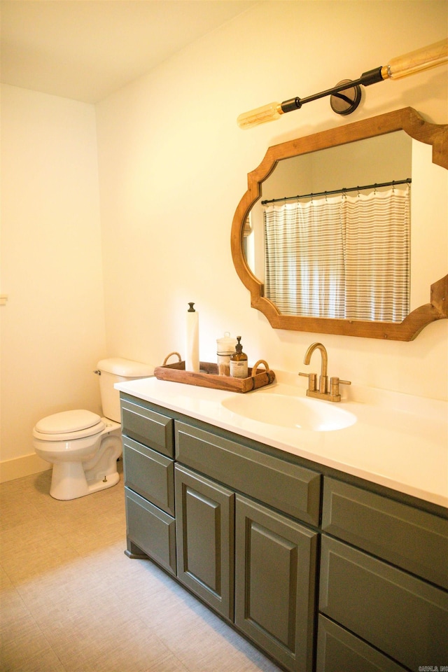 bathroom with tile flooring, vanity, and toilet