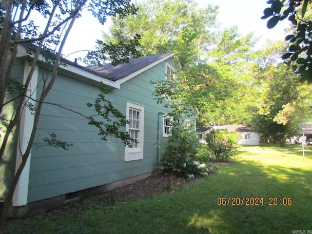 view of side of home with a yard