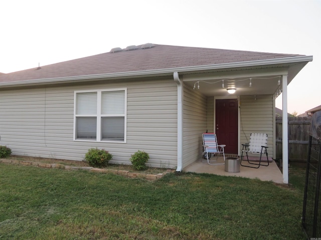 back of property with a yard and a patio area