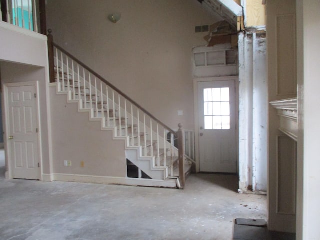 entryway with a towering ceiling and concrete flooring