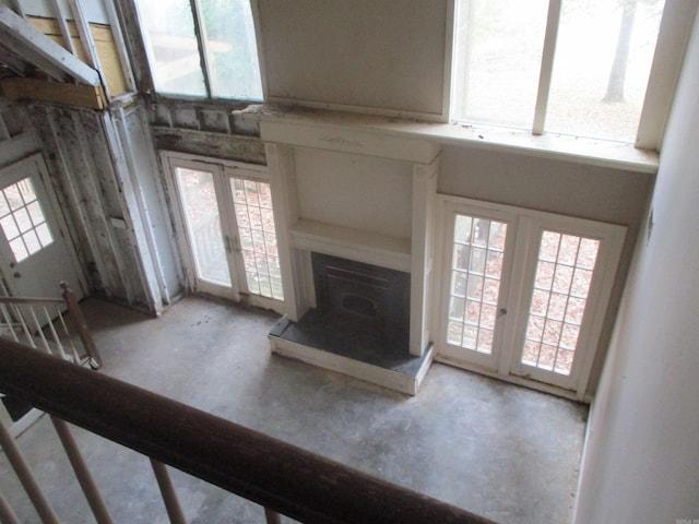 unfurnished living room featuring a healthy amount of sunlight and a wood stove