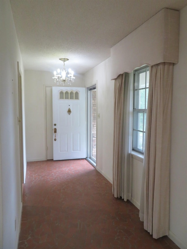 foyer with a textured ceiling and a chandelier