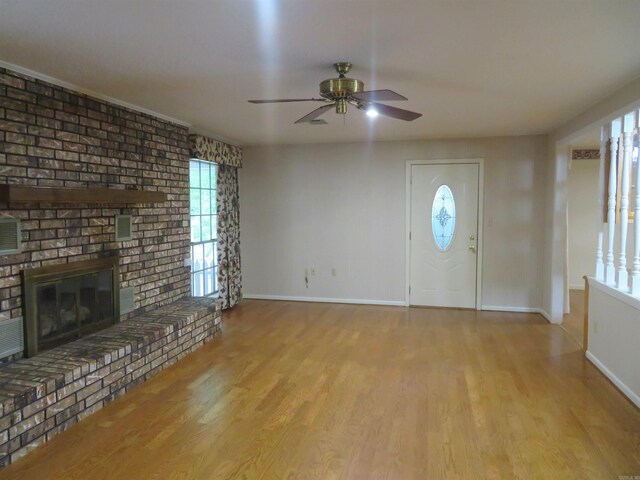 foyer with ceiling fan, a fireplace, and light hardwood / wood-style flooring