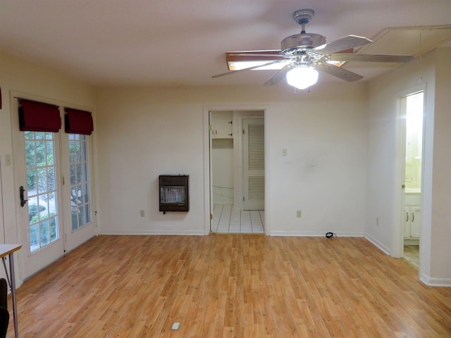 interior space featuring ceiling fan, heating unit, and light wood-type flooring