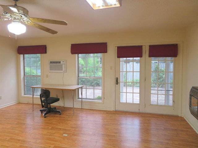 entryway with heating unit, light hardwood / wood-style flooring, an AC wall unit, and ceiling fan