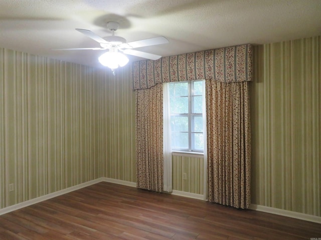 spare room with dark hardwood / wood-style flooring, a textured ceiling, and ceiling fan