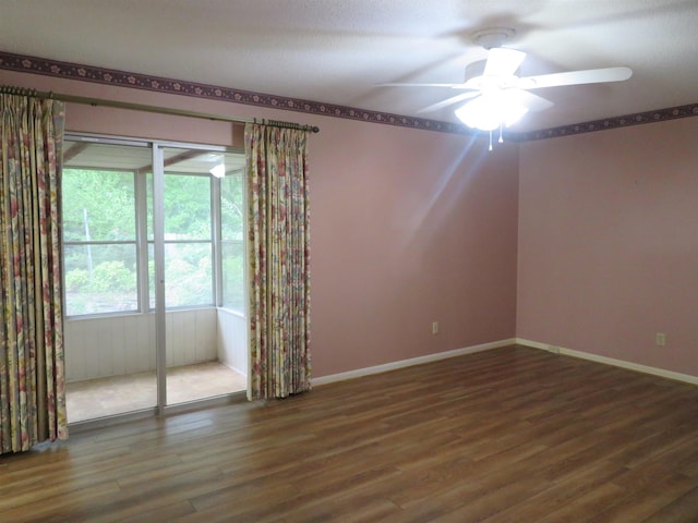 empty room with dark hardwood / wood-style floors and ceiling fan