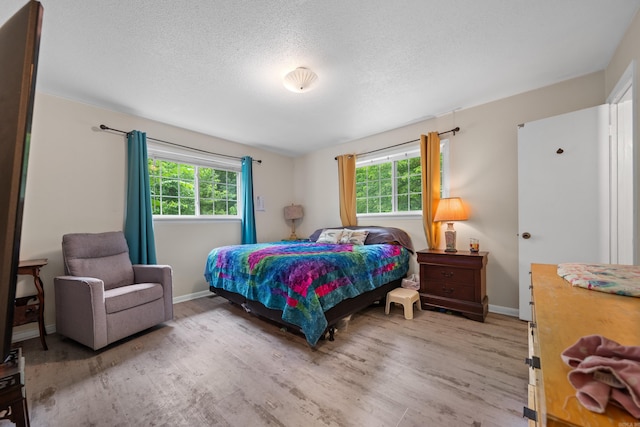 bedroom with hardwood / wood-style floors and a textured ceiling