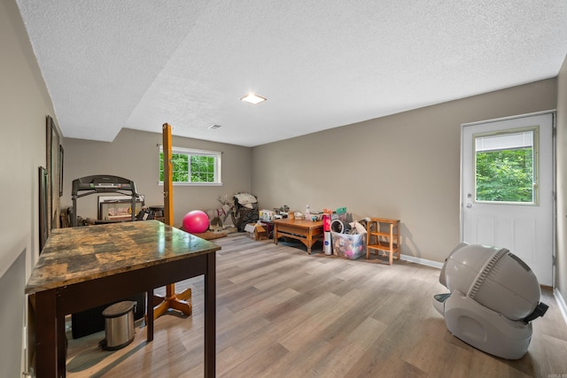 rec room featuring light hardwood / wood-style flooring and a textured ceiling