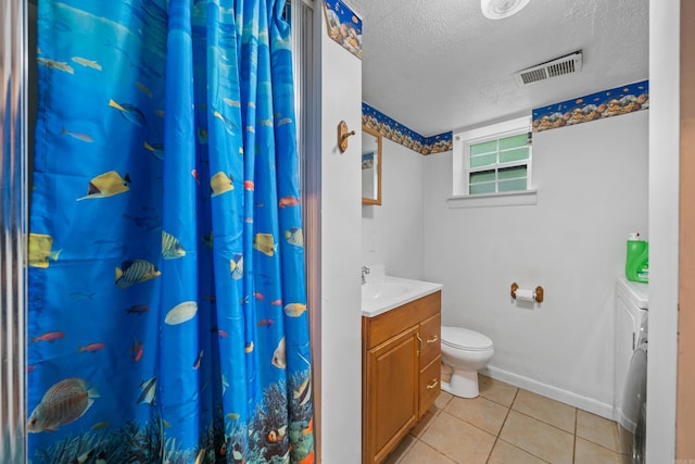 bathroom featuring toilet, a textured ceiling, vanity, washer and clothes dryer, and tile patterned flooring