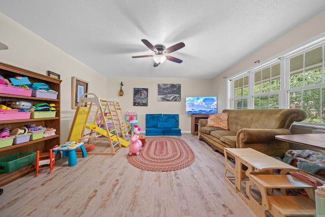 game room with ceiling fan, a textured ceiling, and light hardwood / wood-style floors