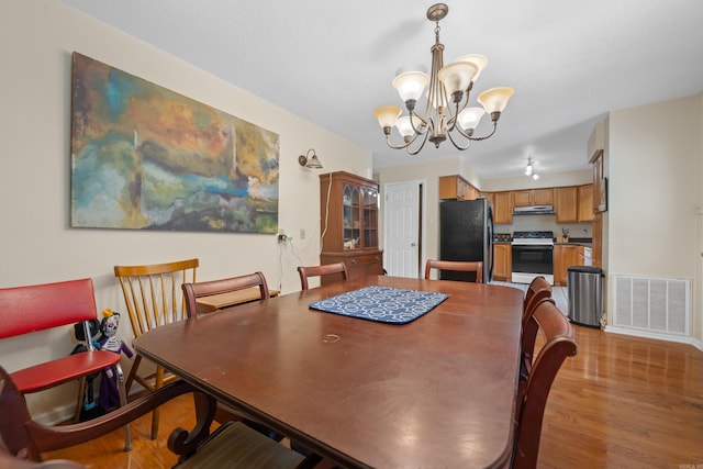 dining space with an inviting chandelier and light wood-type flooring