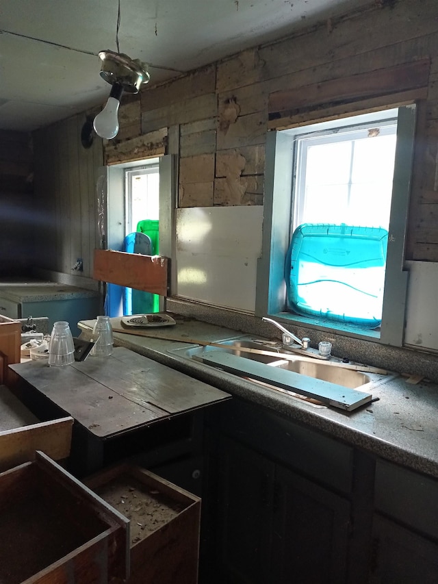 kitchen featuring wood walls and sink