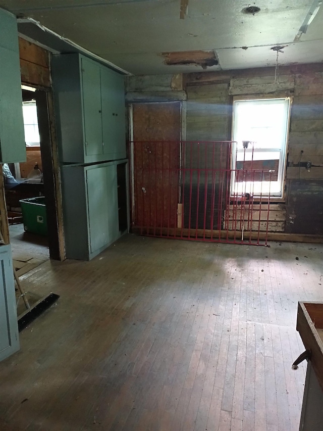 interior space featuring plenty of natural light, light hardwood / wood-style floors, and wooden walls