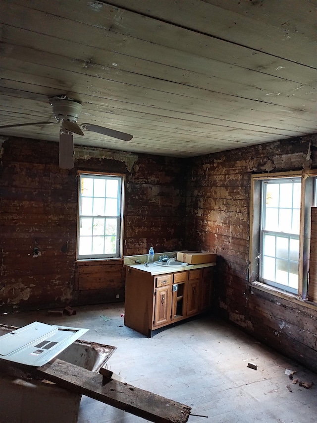 interior space featuring ceiling fan and brick wall