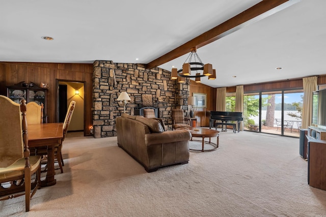 carpeted living room featuring a chandelier, wood walls, and lofted ceiling with beams