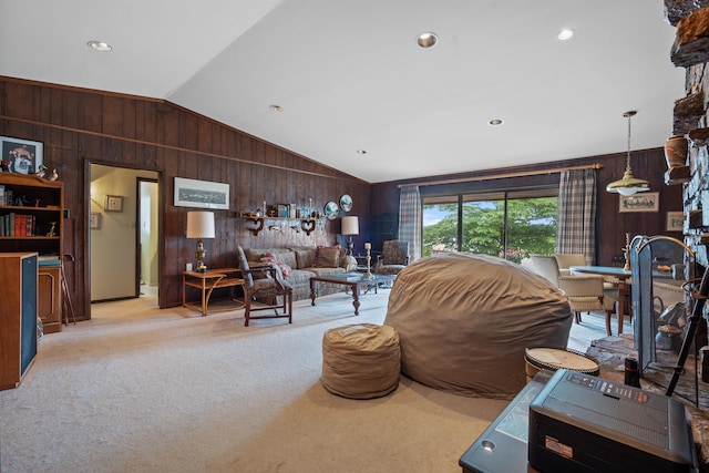 living room with wooden walls, light carpet, and vaulted ceiling