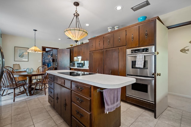 kitchen with light tile patterned floors, black electric stovetop, decorative light fixtures, a kitchen island, and double oven