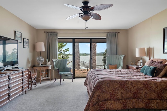 carpeted bedroom with ceiling fan and a water view