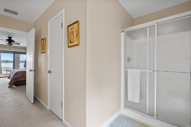 bathroom with ceiling fan and an enclosed shower