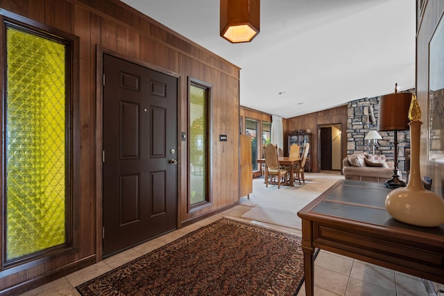 entryway with light tile patterned flooring and wooden walls